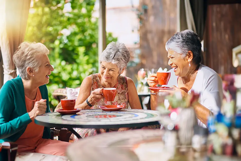 woman sitting around a small table talking and drinking coffee