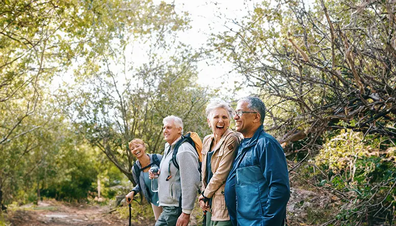 group of senior friends hiking in the woods