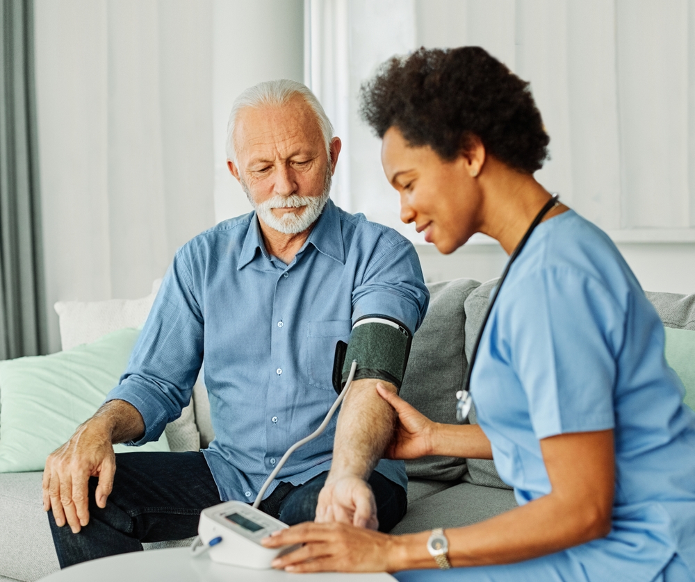 caregiver measuring the blood pressure of a senior man