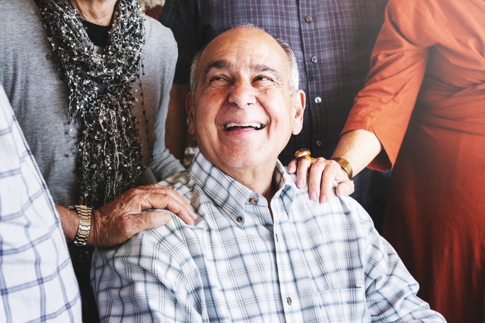 elderly man smiling surrounded by group of senior adults
