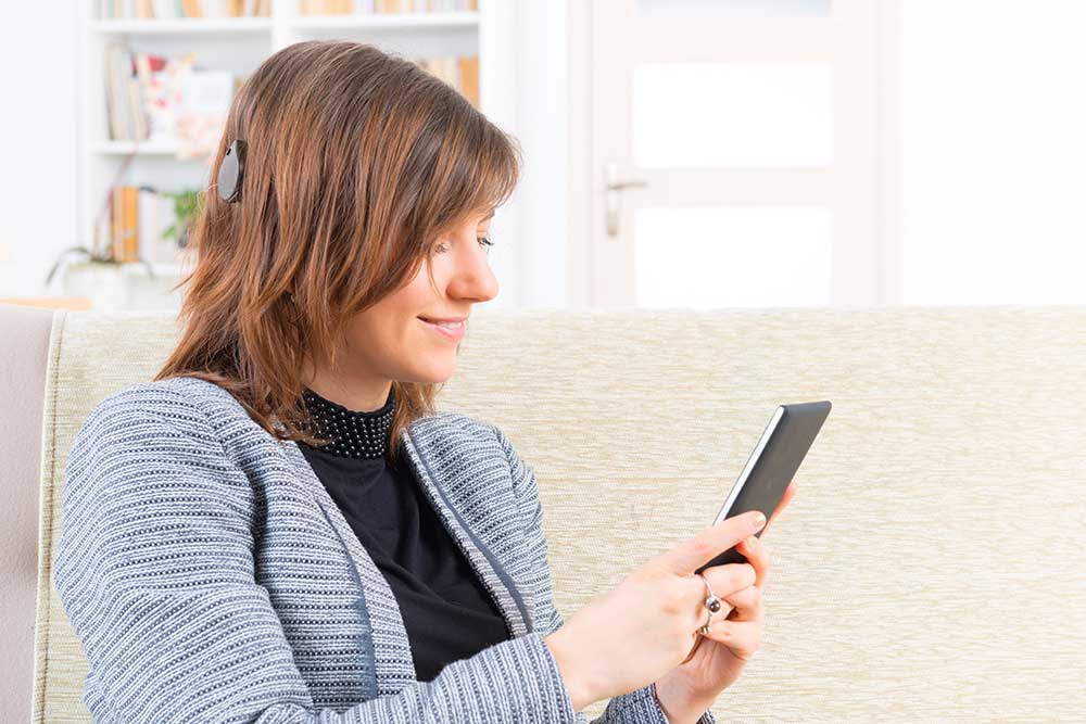 Woman with cochlear implant looking at her phone